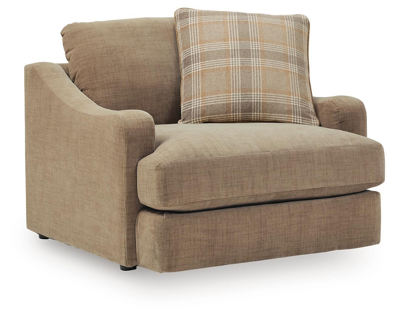 Chair and a half upholstered chair in tan fabric with plaid accent pillow and wide arms