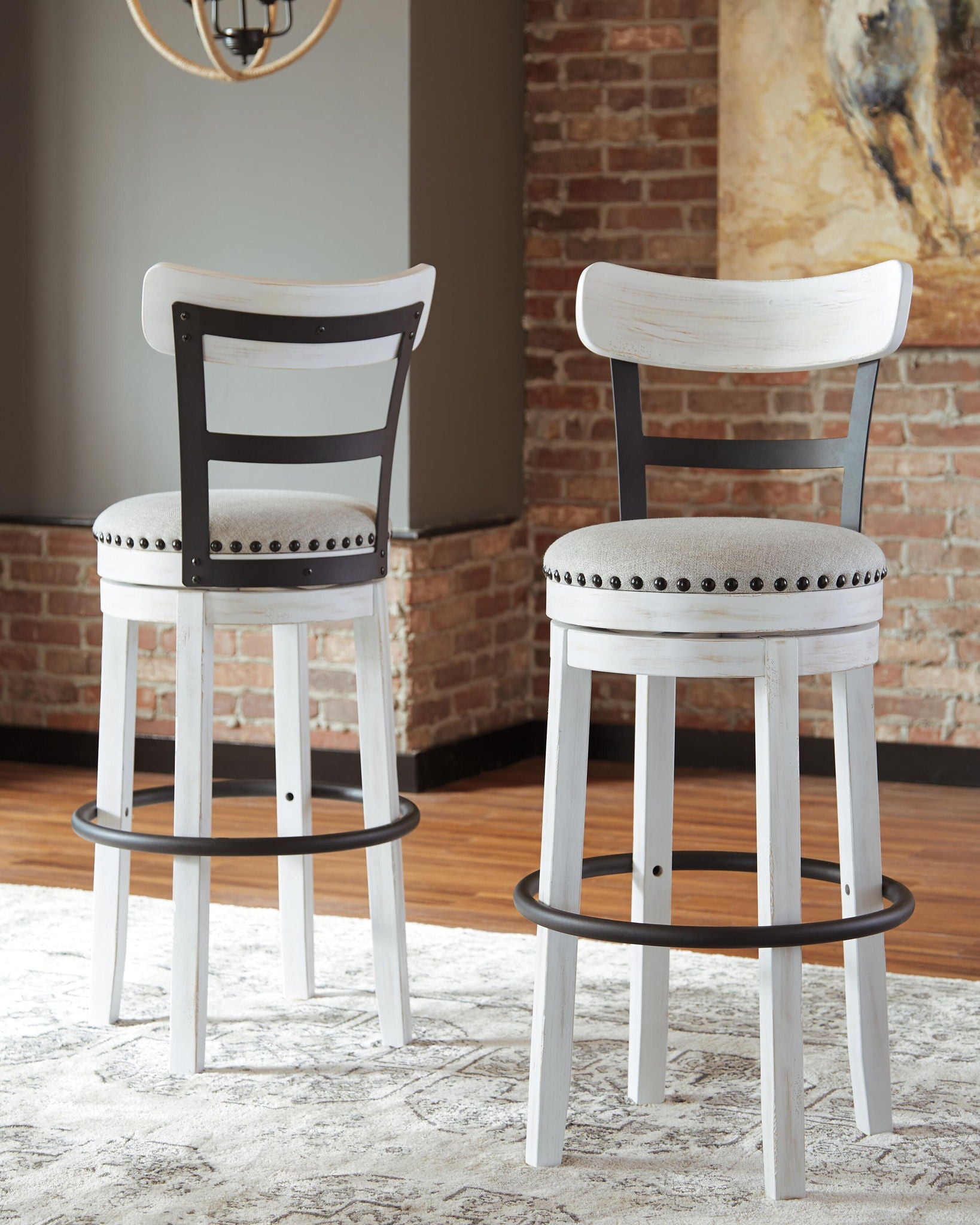 Tall white upholstered swivel barstool with studded seat ring and round footrest