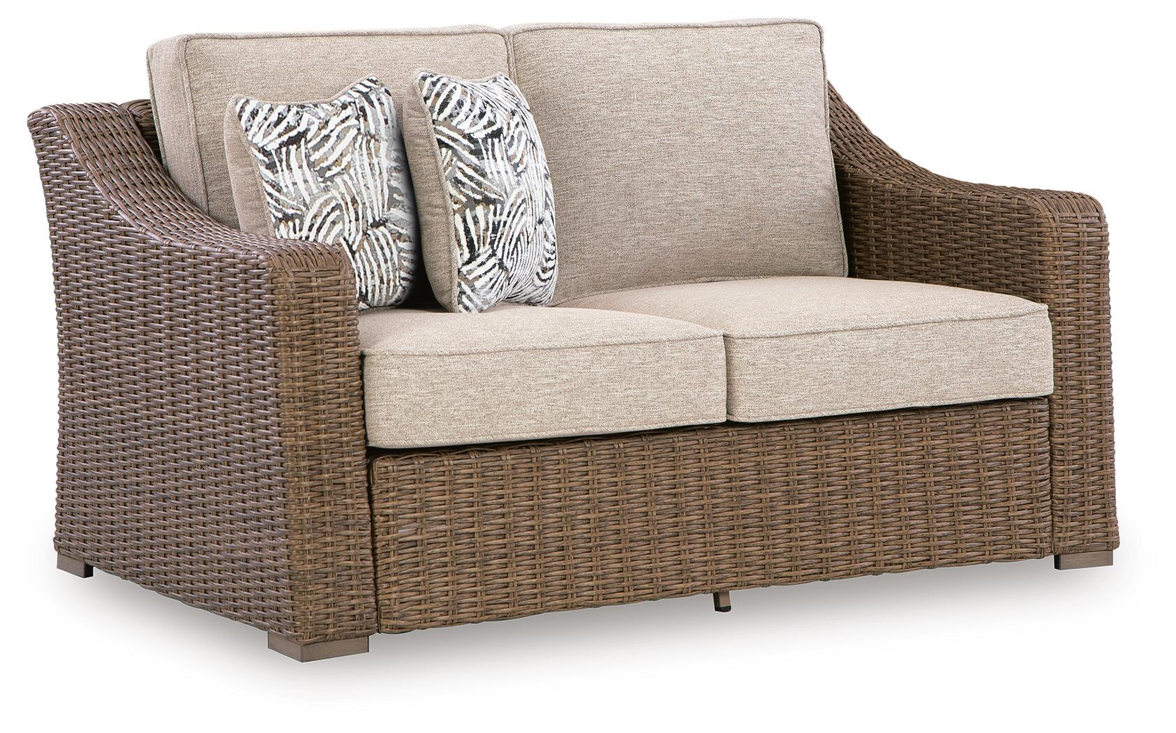 Beige-cushioned woven loveseat with two seat cushions and two patterned throw pillows