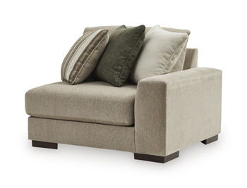 Corner chair in light beige fabric with two throw pillows (green and neutral striped)