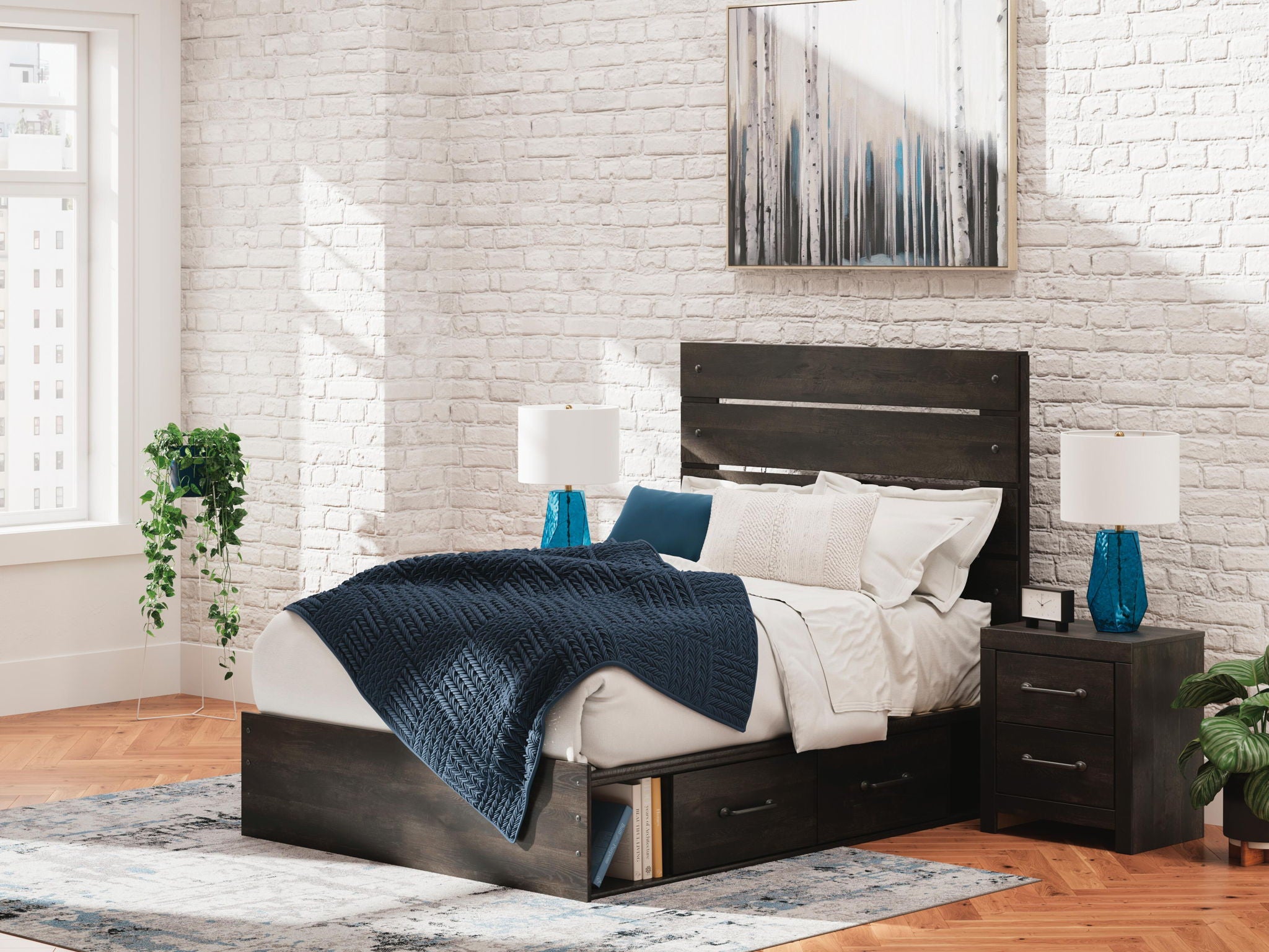Dark gray panel bed with storage drawers, white bedding and blue throw on top