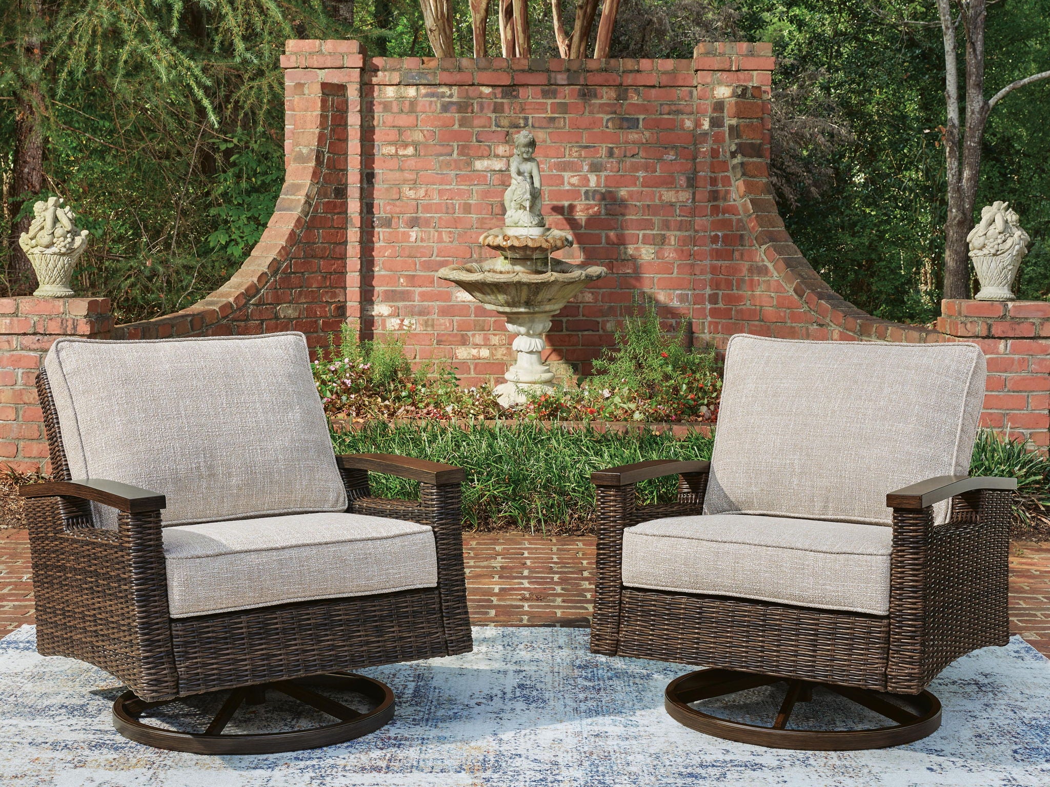 Pair of dark brown woven swivel lounge chairs with beige seat cushions and round base