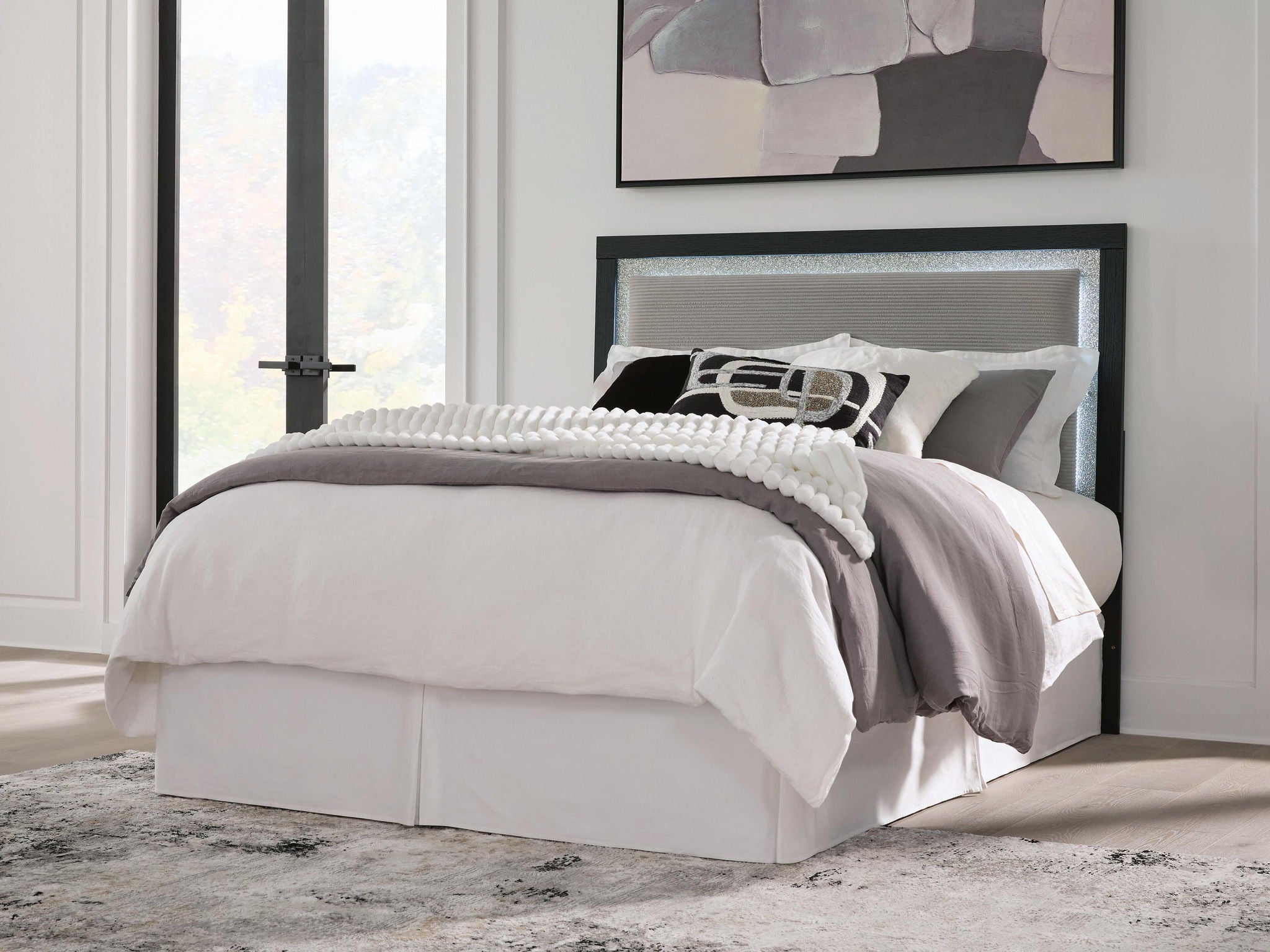Light gray upholstered bed headboard with dark frame, panel back, and pillow top.