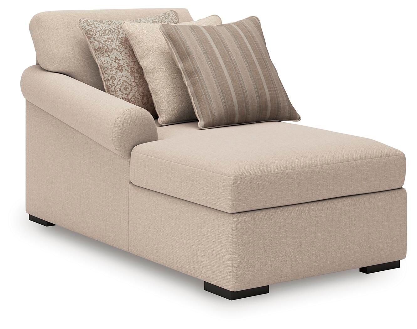 Beige corner chaise with black legs and three throw pillows, striped and patterned
