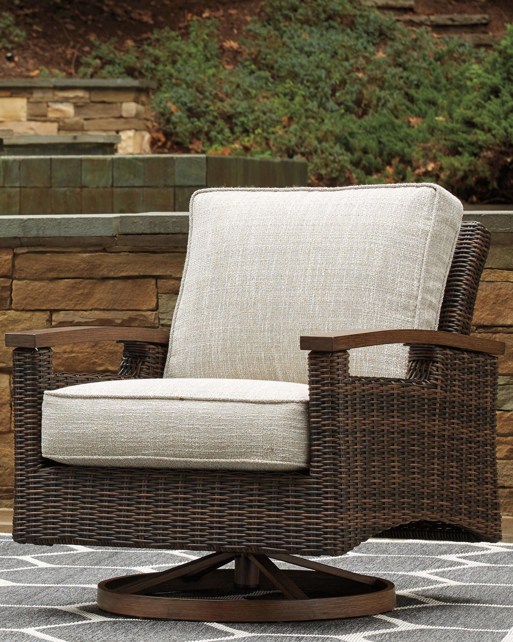 Woven swivel lounge chair with dark brown wicker frame and light beige cushion