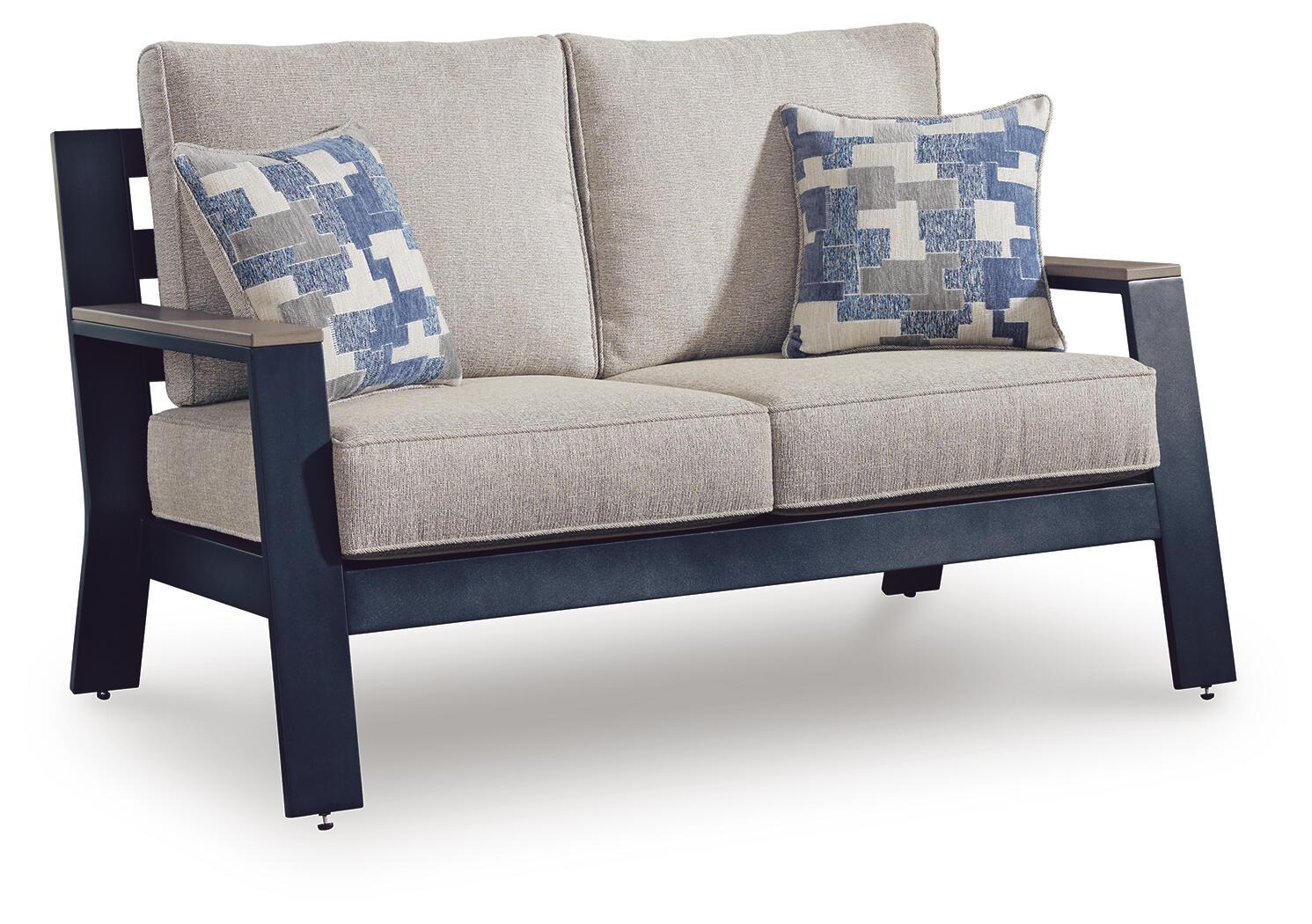 Blue patterned throw cushions on gray loveseat with armrests and two-seat cushion