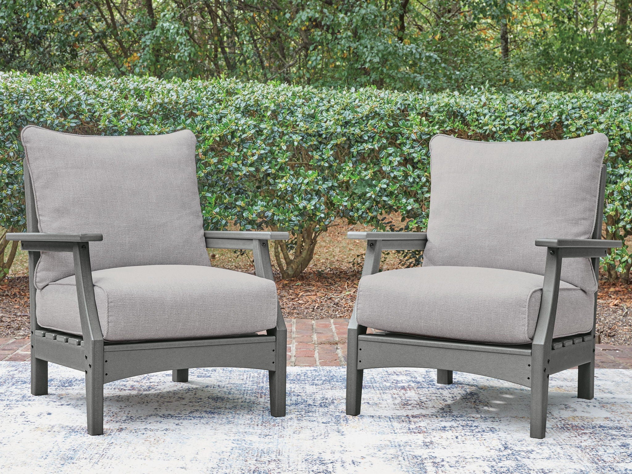 Set of 2 gray outdoor lounge chairs with padded cushions and slatted, sturdy frames