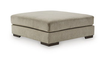 Square upholstered ottoman with thick cushion and dark legs, dune beige fabric.