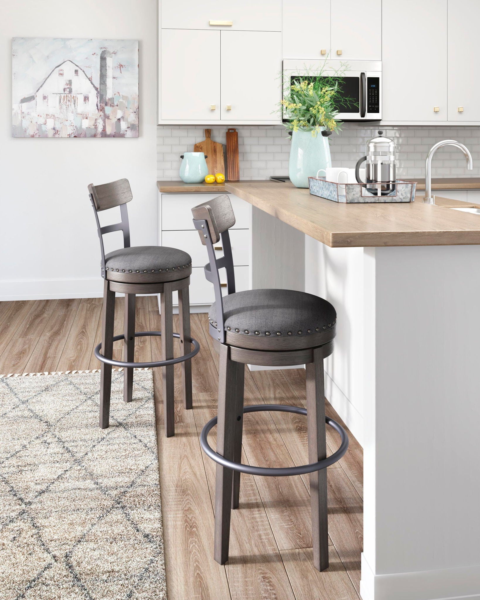 Set of gray upholstered tall swivel barstools with nailhead trim and circular footrests