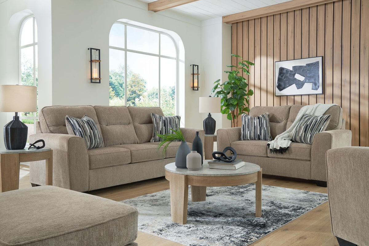 Light brown fabric living room set with striped pillows and coordinating ottoman