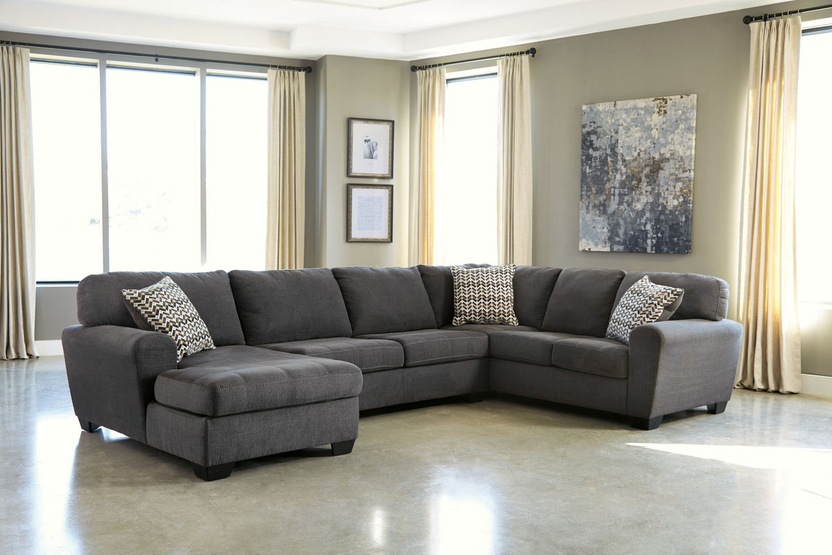 Slate sectional sofa with chaise and two patterned throw pillows on dark gray upholstery