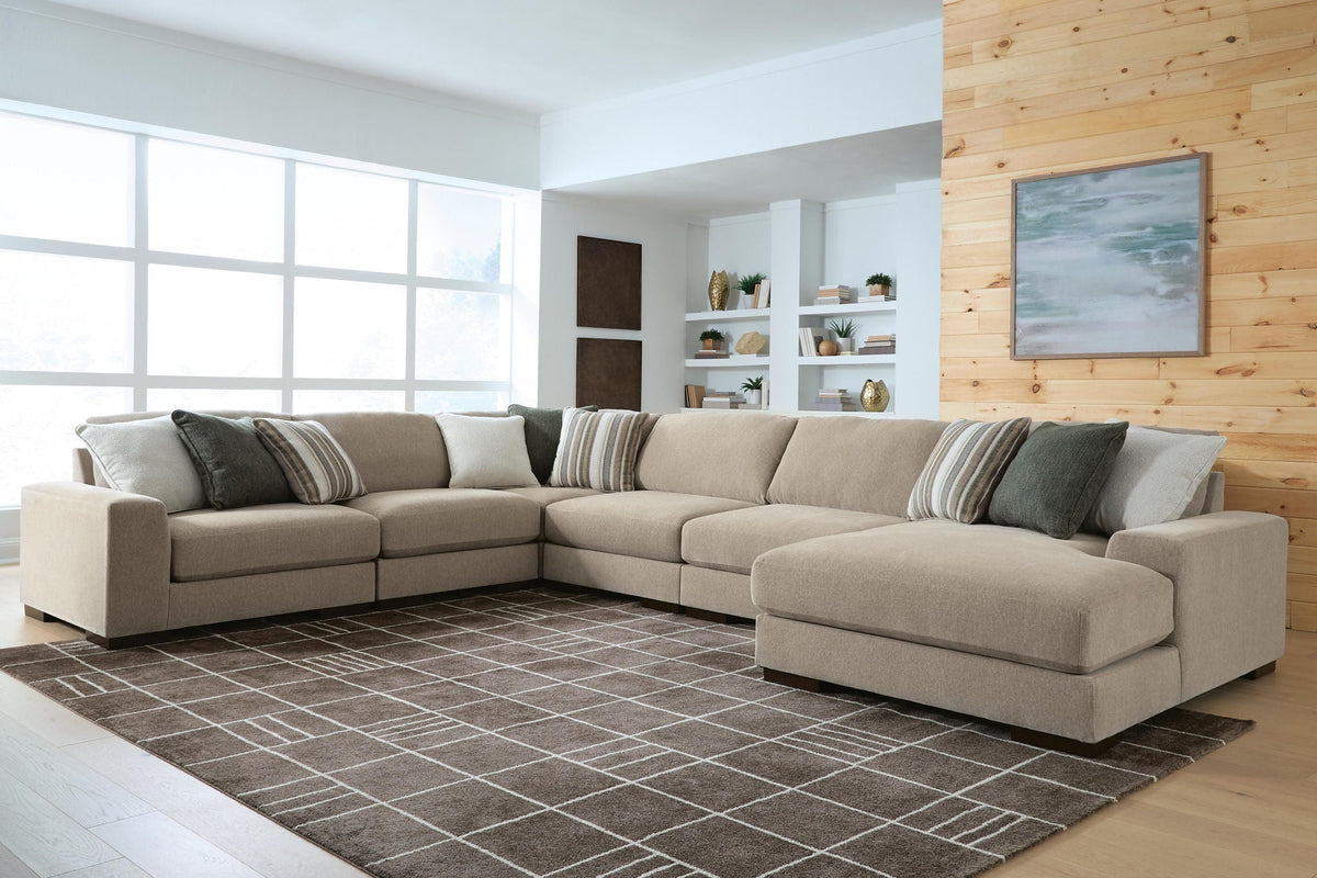 Light brown sectional sofa with chaise end and striped throw pillows