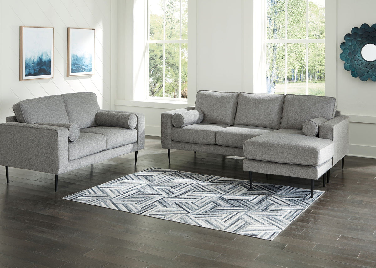Charcoal gray loveseat sofa with chaise, rounded arm cushions and two round back pillows