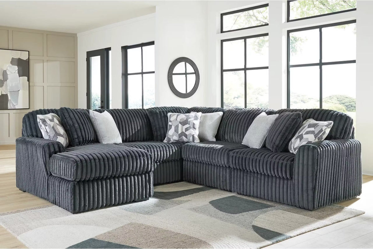 Blue-gray corduroy sectional sofa with corner chaise and patterned accent pillows