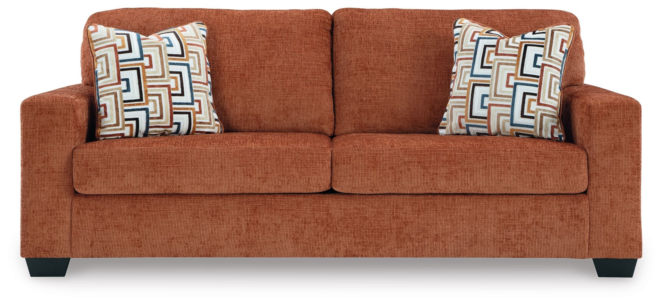Spice rust sofa sleeper with two patterned throw pillows, centered front view.