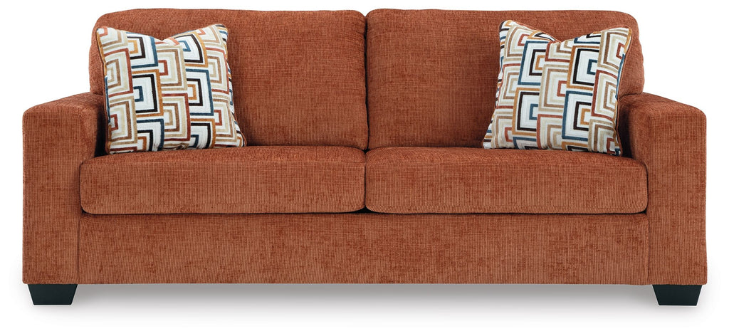 Warm rust sofa with two patterned throw pillows and low square arms