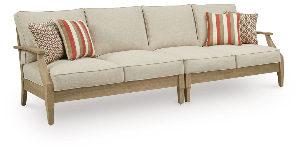 Beige loveseat with cushions and two striped throw pillows