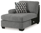 Gray corner chaise lounge with upholstered back, patterned throw pillow, black legs