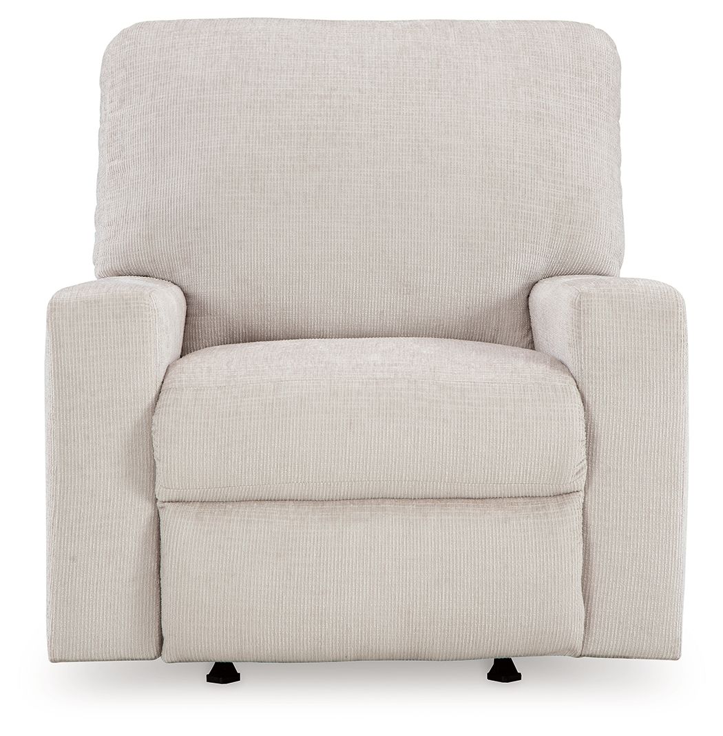 Rocker recliner chair in light beige upholstered fabric with front armrests and seat pad.