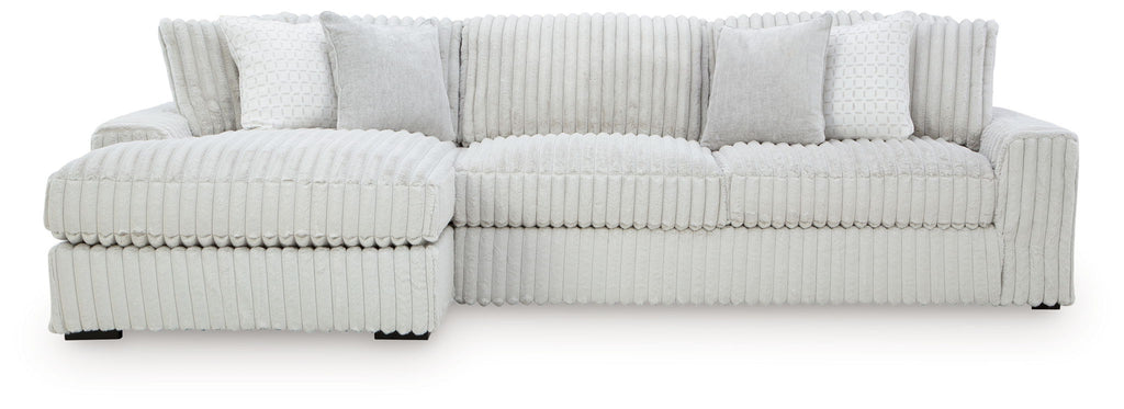 Sectional sofa with chaise, light-colored striped upholstery and padded arm cushions
