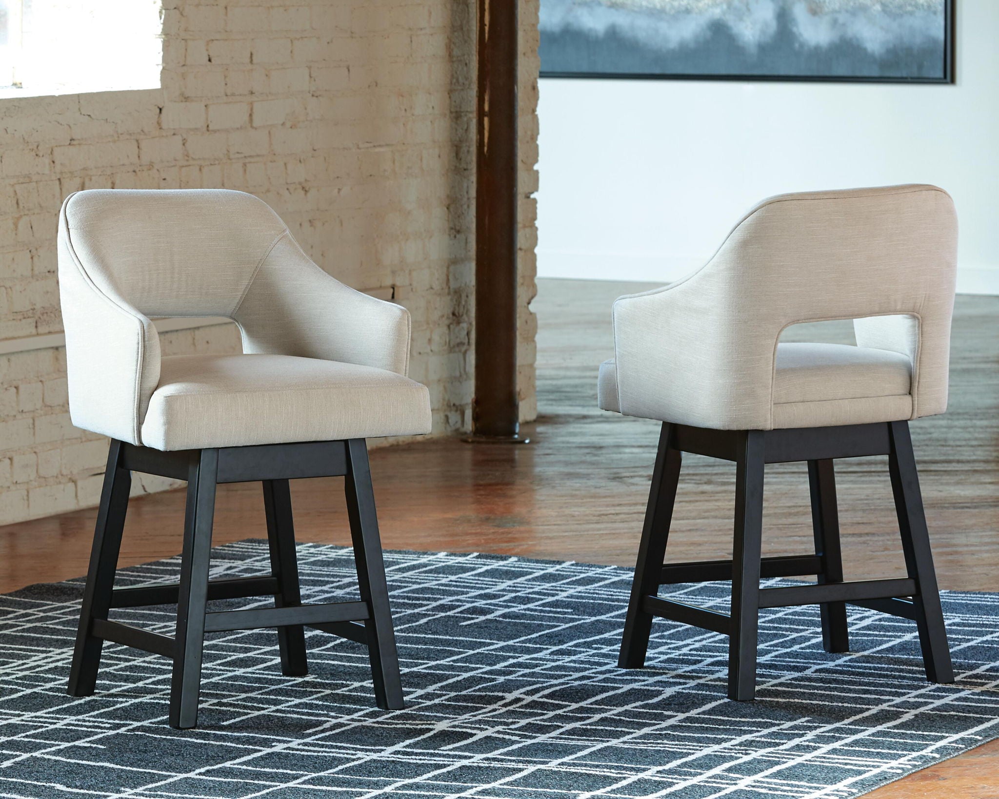 Beige upholstered barstools with wide arms, curved back, and black four-leg bases, set of 2
