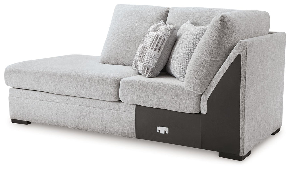 Corner chaise in light gray upholstery with two pillows and dark side arm panel