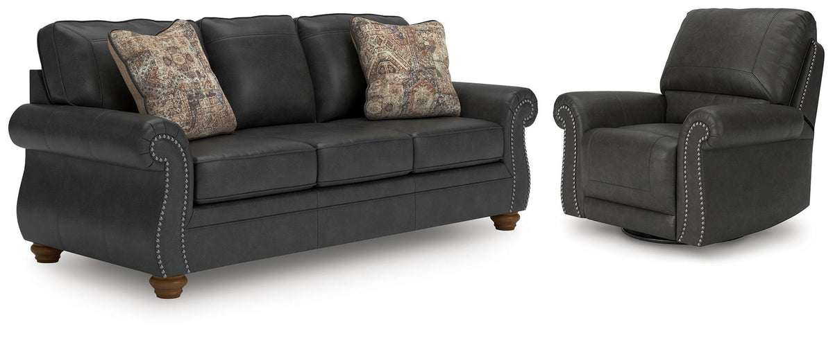 Dark gray sofa with two patterned accent pillows and matching recliner chair