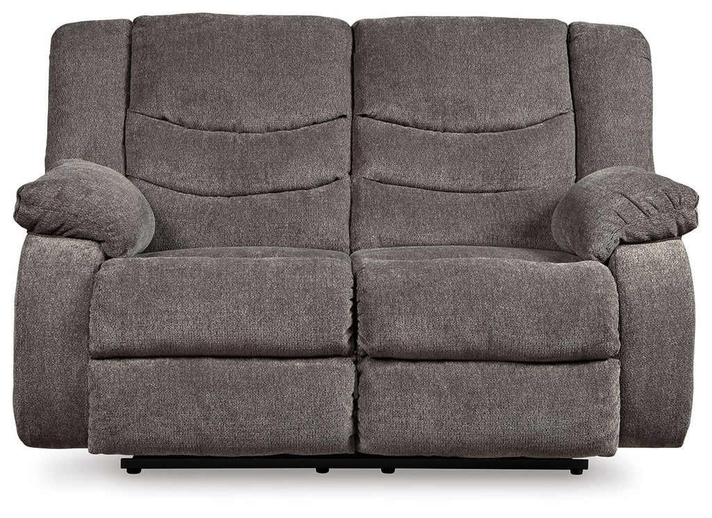 Gray reclining loveseat with padded arms, split back cushions, and recline footrest