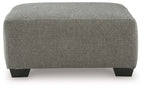 Boxy gray upholstered ottoman with dark legs and rounded top edge