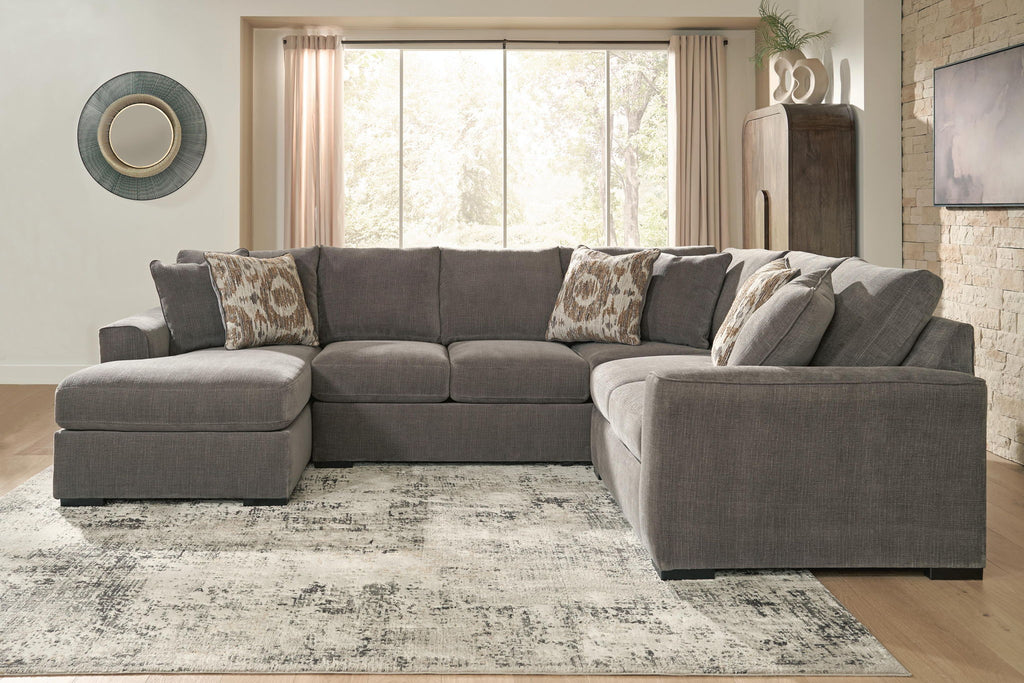 Gray sectional sofa with chaise, decorative patterned pillows, and wide chaise cushion