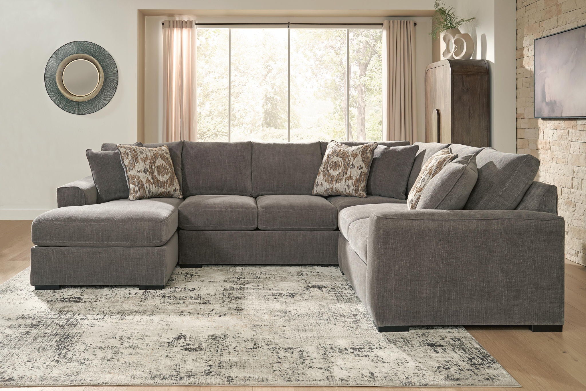Gray sectional sofa with chaise, decorative patterned pillows, and wide chaise cushion