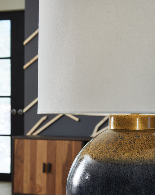 Blue metal table lamp base with gold collar and white fabric shade