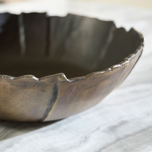 Antique gold metal bowl rim with dark interior, textured hammered finish