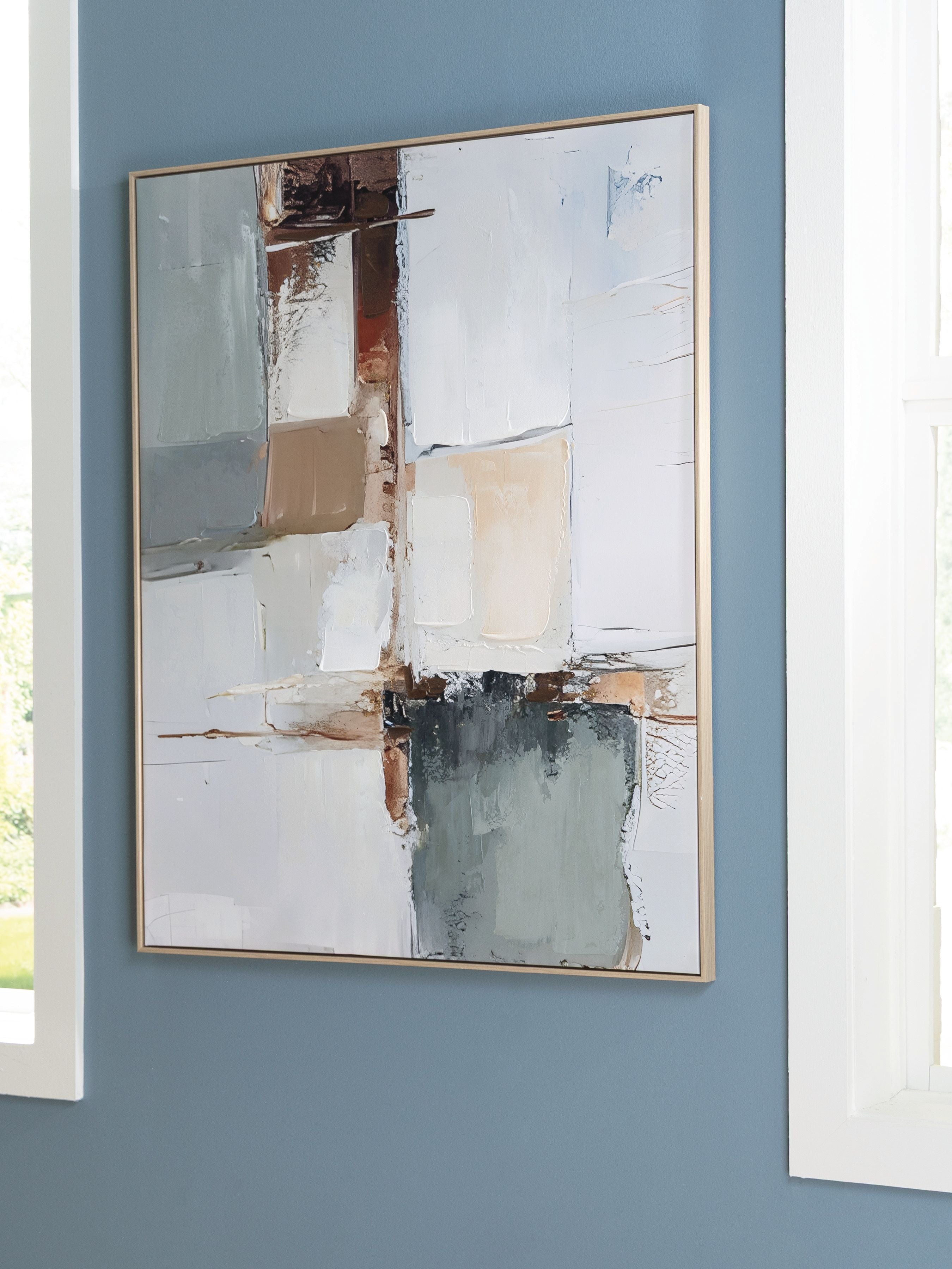 Framed abstract wall art with layered white, blue, and brown geometric shapes