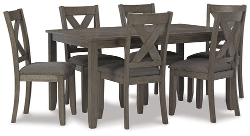 Gray dining table with four upholstered chairs in view, cross-back chair design