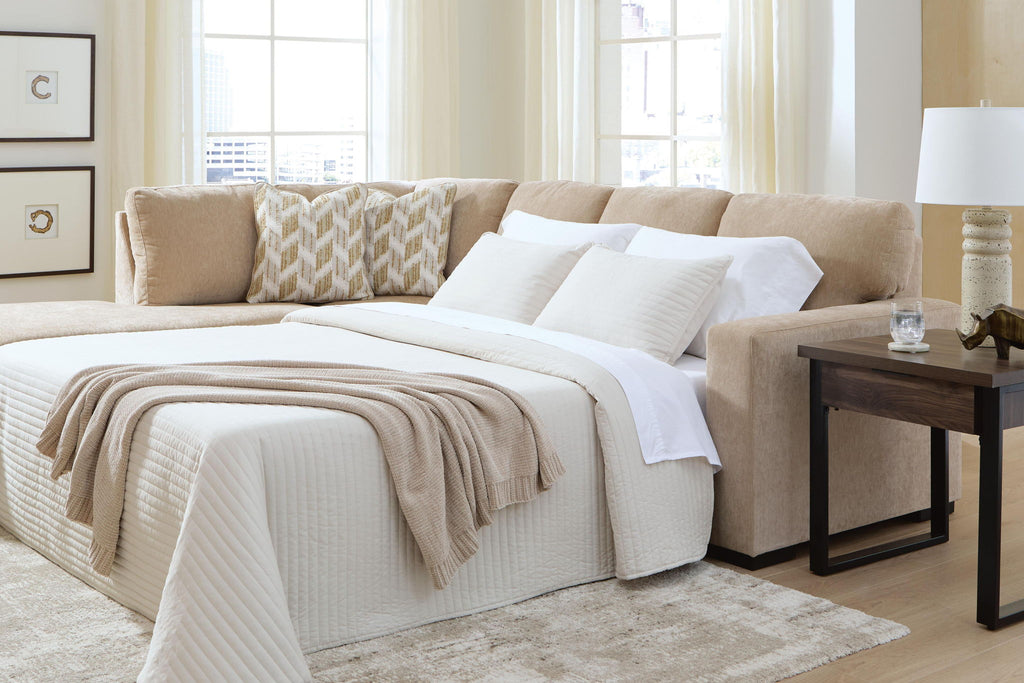 Light brown sleeper sectional with open bed platform, white bedding, and corner cushions