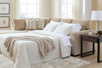 Light brown sleeper sectional with open bed platform, white bedding, and corner cushions