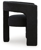 Dark upholstered accent chair with wide frame, curved armrests, and block feet