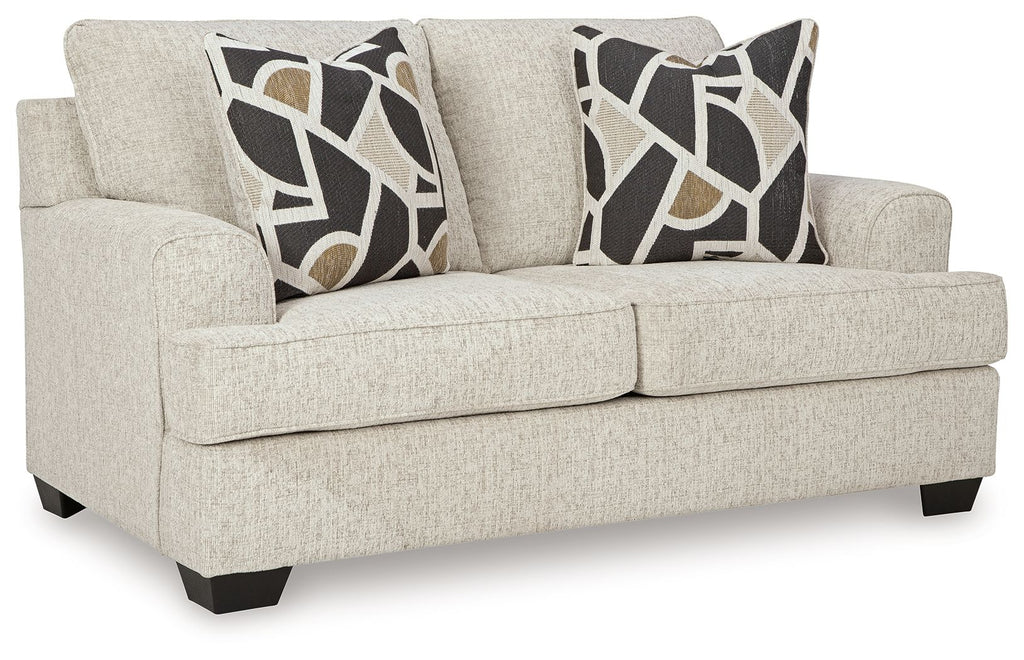 Light beige loveseat with square arms and two geometric black-and-beige throw pillows