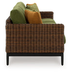 Woven wicker sofa with green cushions, brown accent pillow, and black legs