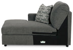Dark gray corner chaise with backrest and gray-and-white patterned throw pillow