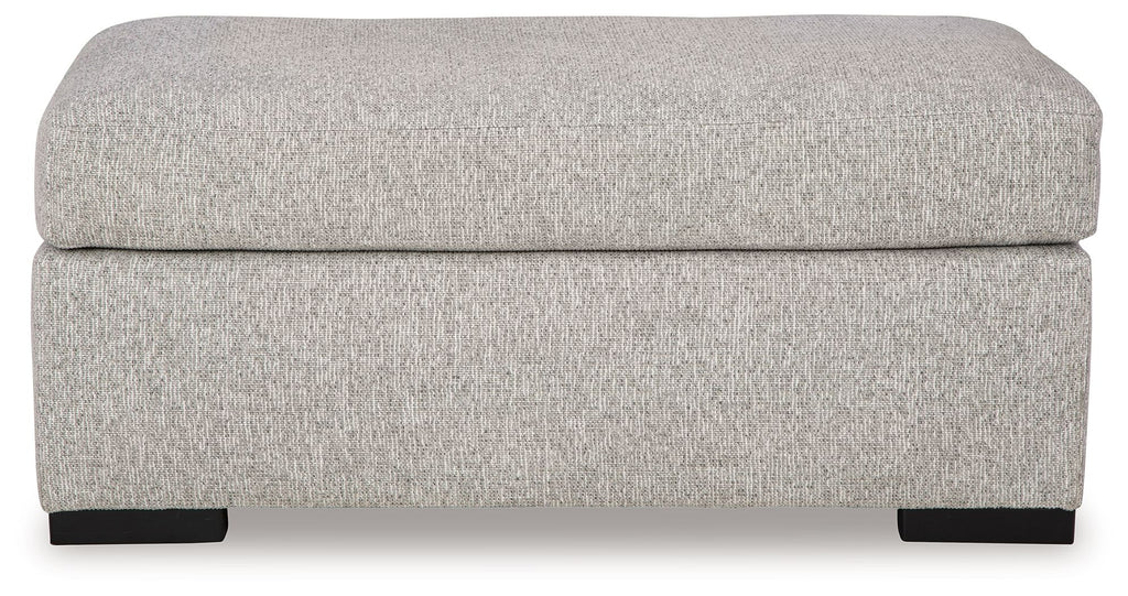 Light gray upholstered ottoman with rounded cushioned top and dark legs