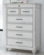 White paneled dresser with five drawers and curved metal pulls on turned feet