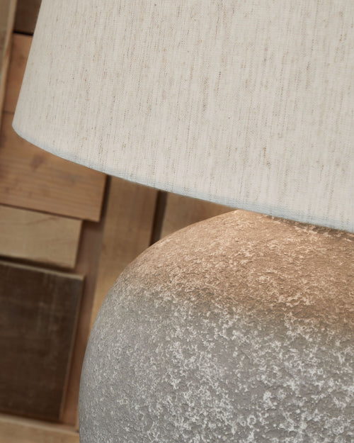 Distressed gray lamp base texture under paper shade fabric