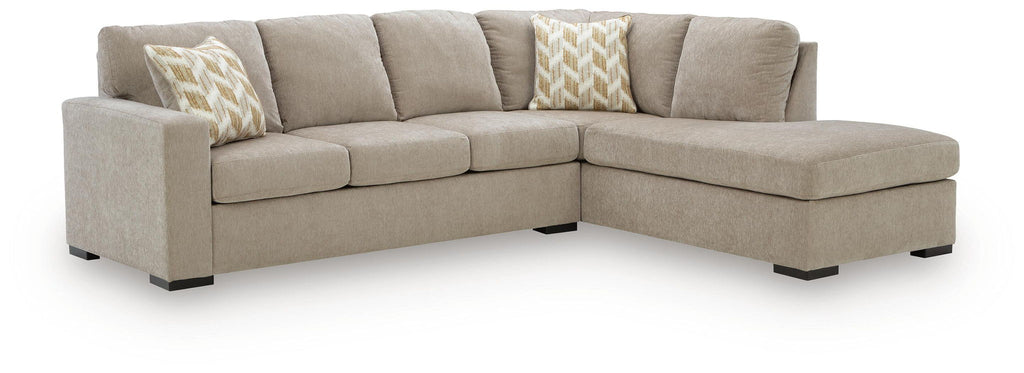 Stone beige sectional sofa with corner chaise and two patterned throw pillows