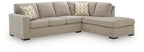 Stone beige sectional sofa with corner chaise and two patterned throw pillows