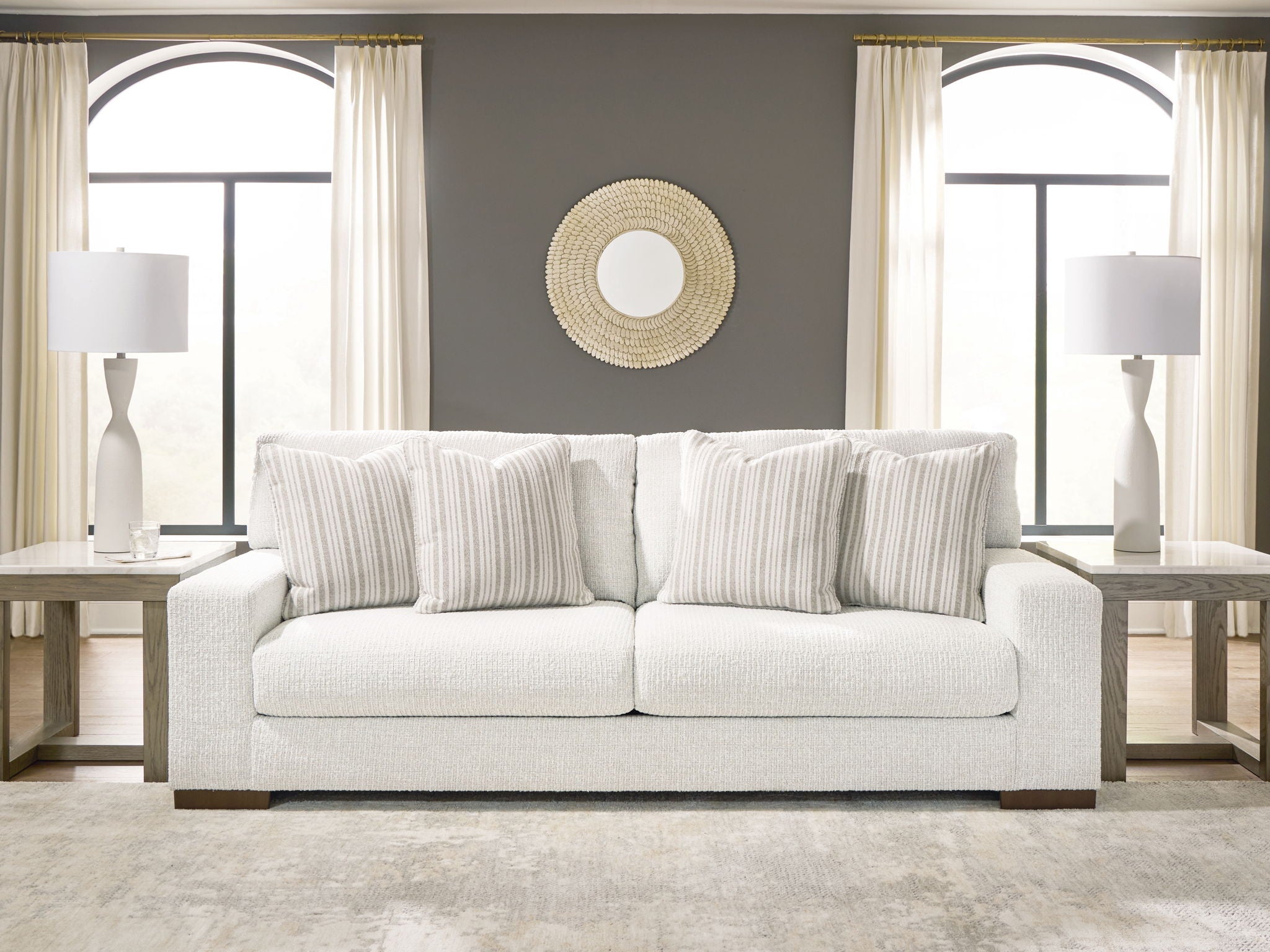 Hartside sofa in off-white fabric with three striped pillows and dark wood legs