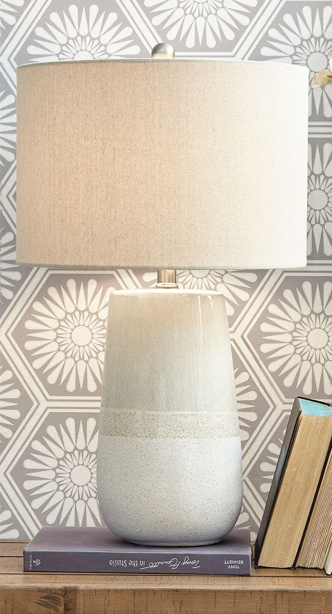 Beige fabric table lamp shade over speckled ceramic base with band detail