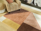Geometric area rug with rust, dark brown, cream, and yellow panels
