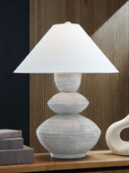 Distressed white table lamp with wide drum shade and sculpted round base